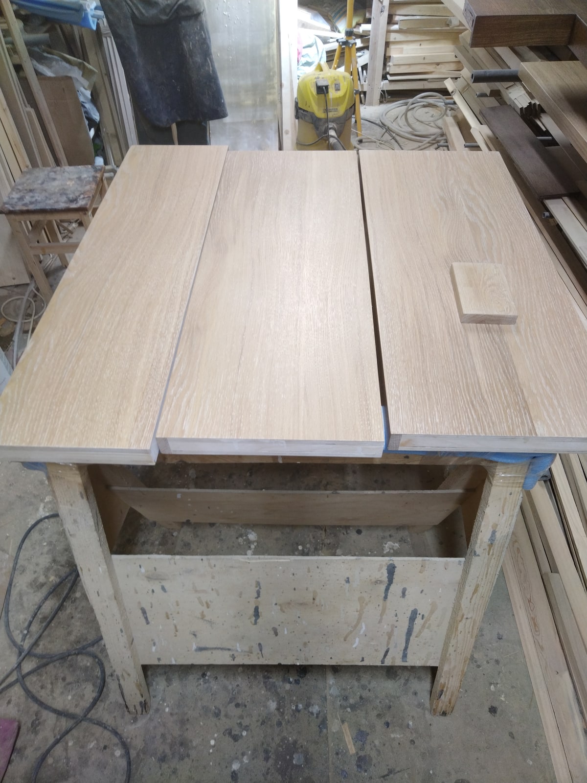 Несколько длинных деревянных деталей на производственном столе