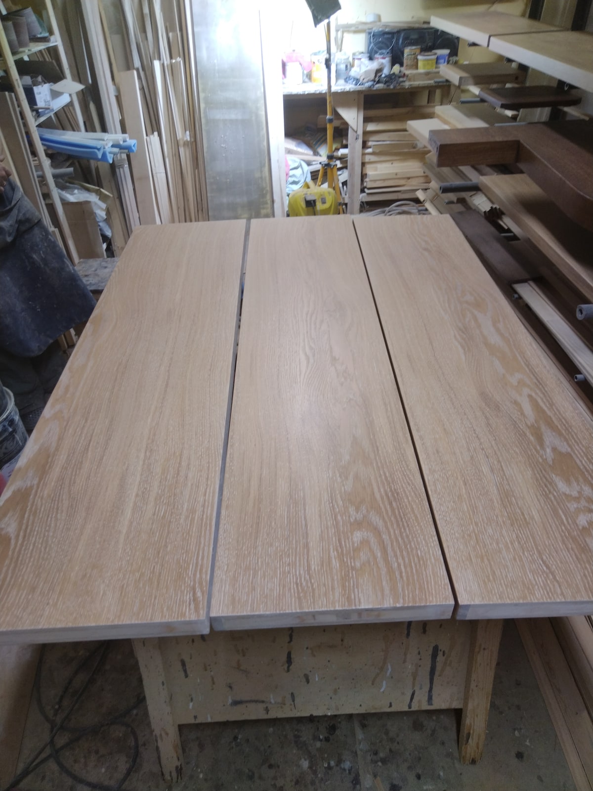 Серия длинных деревянных деталей на сборочном столе в мастерской